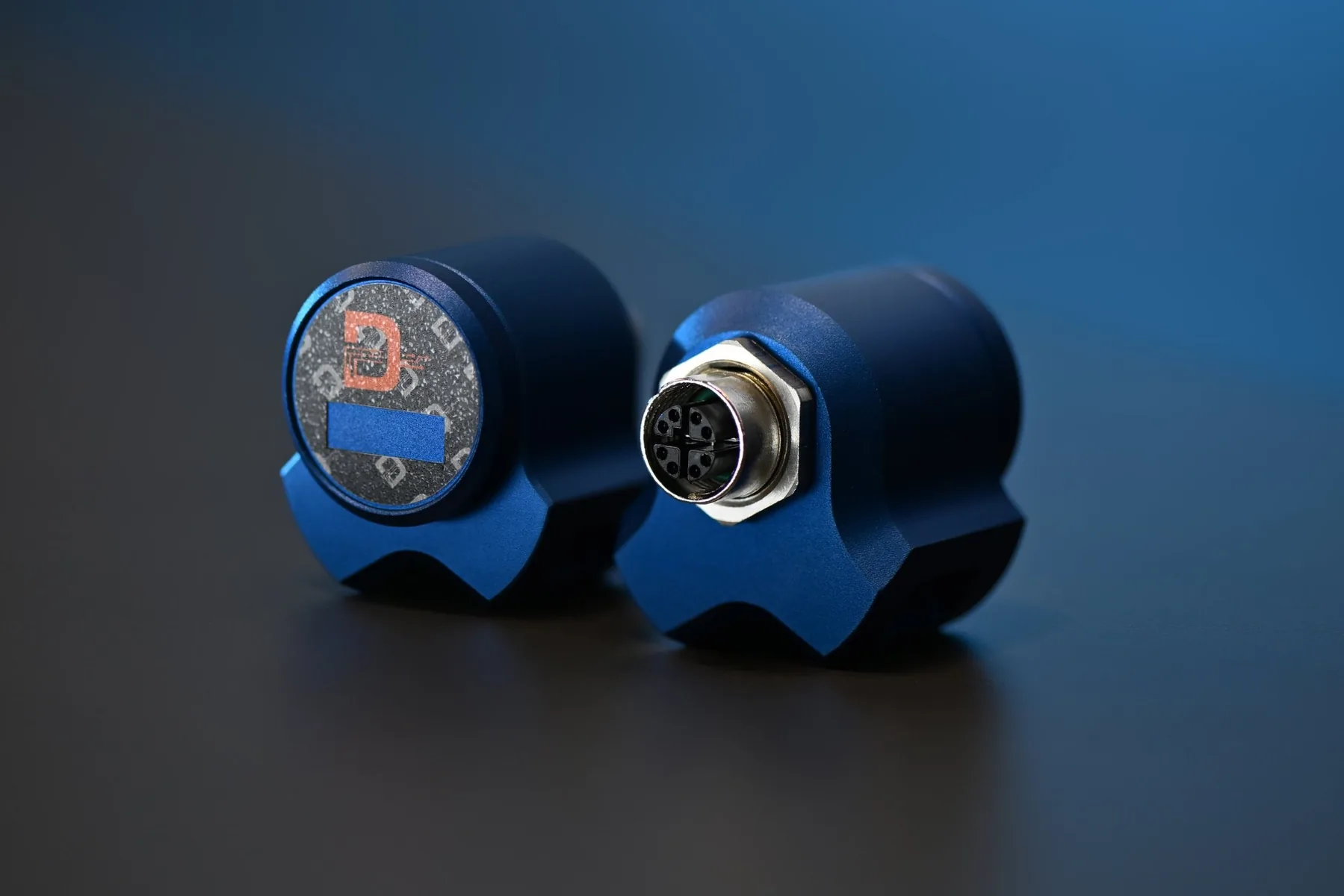 Two D-RAIL Sensor Units, one showing its label, the other its M12 socket